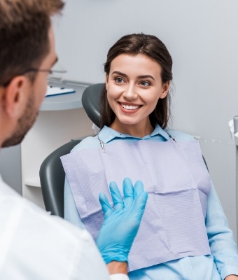 Dentist talking to young woman in dental chair