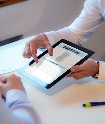 Patient reviewing dental insurance forms on tablet