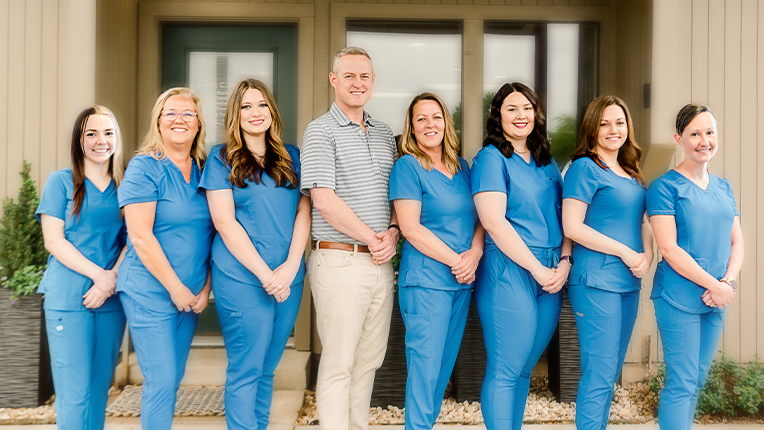 Claremore dentist and dental team standing outside of Battle Family Dentistry of Claremore