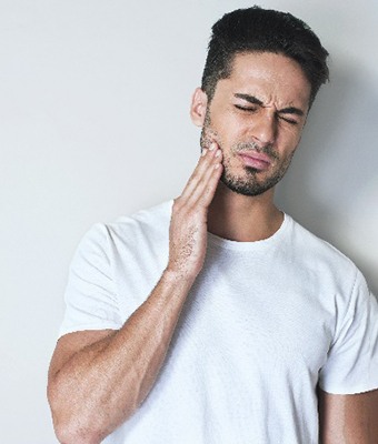 Closeup of man in white shirt experiencing toothache