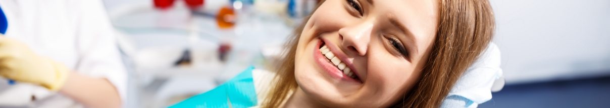 Close up of young woman grinning in dental chair
